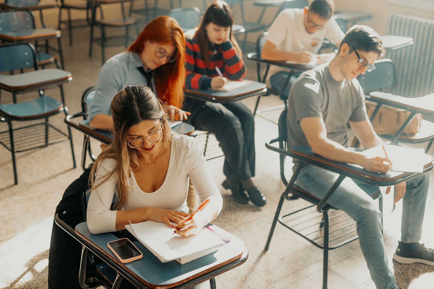 Estudiantes presentando una prueba escrita en el aula